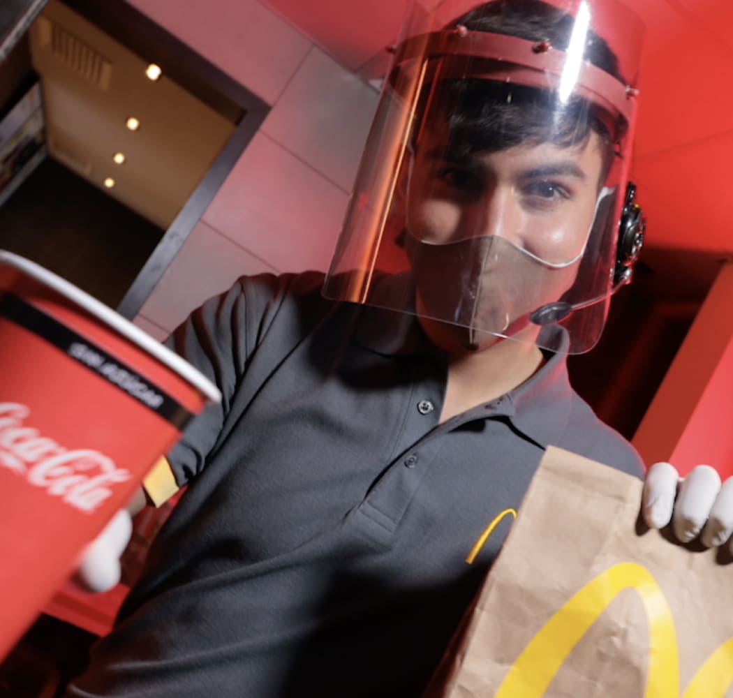 Empleado de McDonald's con un combo en la mano de Automac.
